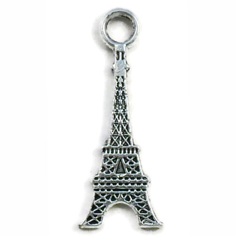 May include: Silver charm shaped like the Eiffel Tower with a loop at the top for attaching to a bracelet or necklace.
