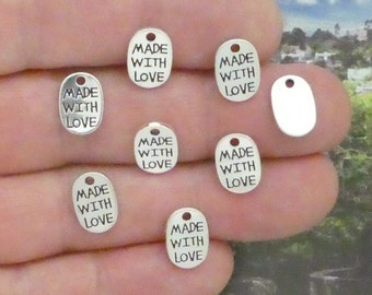 May include: Seven silver oval-shaped charms with the text "Made with Love" on each charm. One charm is blank.
