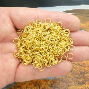 May include: A large pile of gold jump rings, perfect for jewelry making or crafting projects.