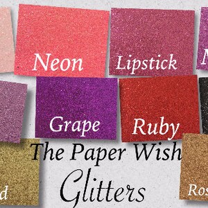 May include: A collection of glitter paper samples in various colours, including blush, neon, lipstick, magic, plum, grape, ruby, onyx, gold, and rose gold. The text "The Paper Wish Glitters" is printed below the samples.