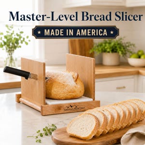 May include: A wooden bread slicer with vertical guide slots and a white base, featuring the text Master-Level Bread Slicer and MADE IN AMERICA. A black-handled knife is inserted into the guide, slicing a loaf of bread, with sliced bread nearby.