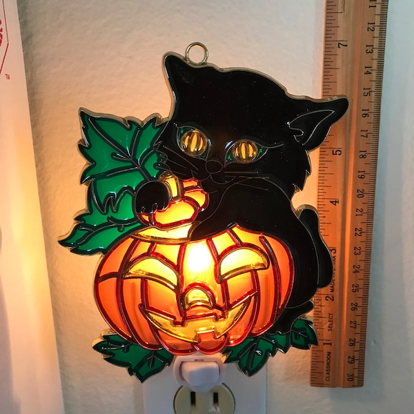 Luz de noche de gatito negro con calabaza