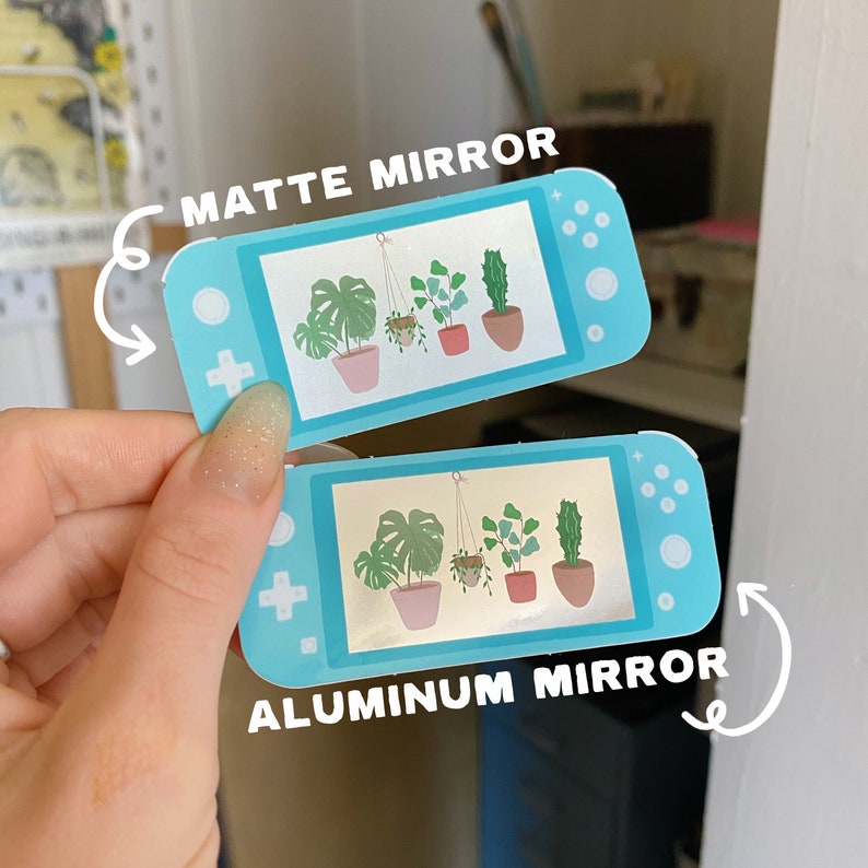 May include: Two Nintendo Switch Lite stickers with a design of potted plants. The top sticker says "Matte Mirror" and the bottom sticker says "Aluminum Mirror".