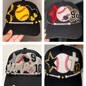 May include: Four black baseball caps with mesh back panels. Each cap features a different design with a baseball, star, heart, and numbers. The caps have beaded trim with white beads and black and yellow beads.