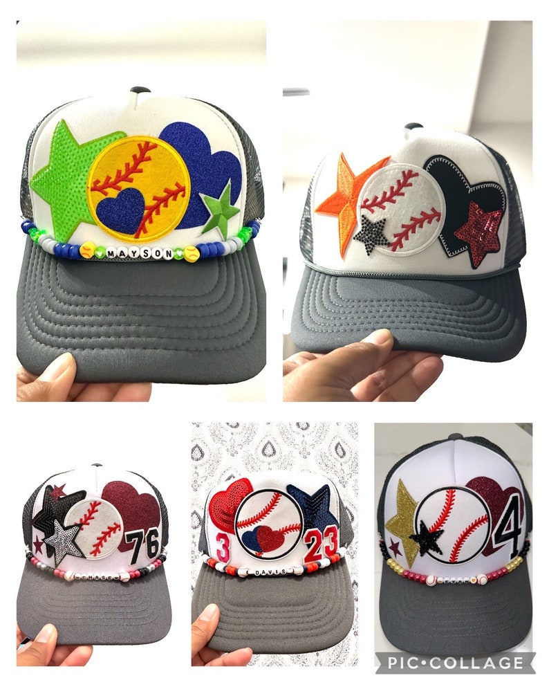 May include: Four gray and white baseball caps with different colored patches and embellishments. The caps have a mesh back and a gray brim. The patches include a baseball, a heart, a star, and numbers. The caps are decorated with beads and charms.