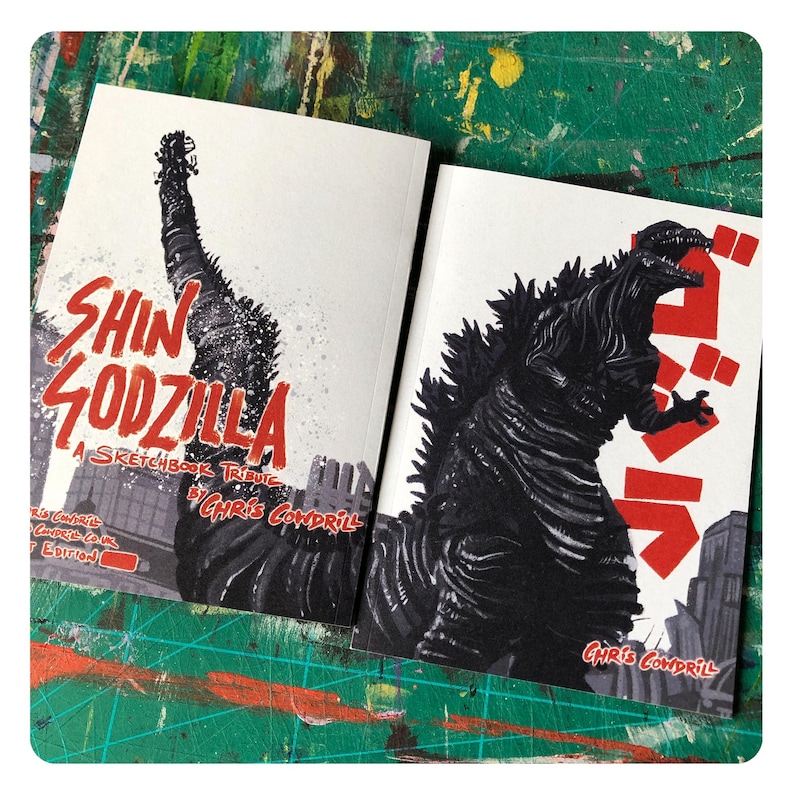 Op de afbeelding: Een schetsboek-tribute aan Shin Godzilla, een Japanse monsterfilm. De omslag toont een zwart-witte illustratie van Godzilla met de titel "Shin Godzilla: A Sketchbook Tribute by Chris Cowdril" in rood-witte tekst.