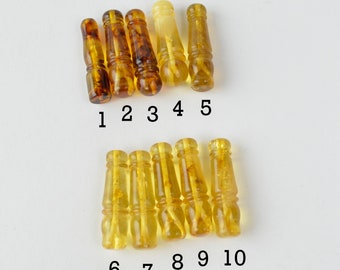 May include: Ten amber beads, each with a unique pattern and color variation. The beads are numbered 1 through 10, with the first five beads being darker in color and the last five beads being lighter in color.