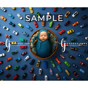 May include: A newborn baby wrapped in a teal blanket, nestled in a woven basket, surrounded by a collection of colorful toy cars on a blue background. The word "SAMPLE" is displayed in white text.