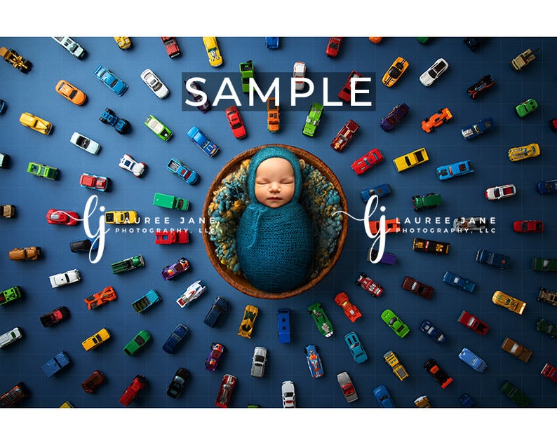 May include: A newborn baby wrapped in a teal blanket, nestled in a woven basket, surrounded by a collection of colorful toy cars on a blue background. The word "SAMPLE" is displayed in white text.