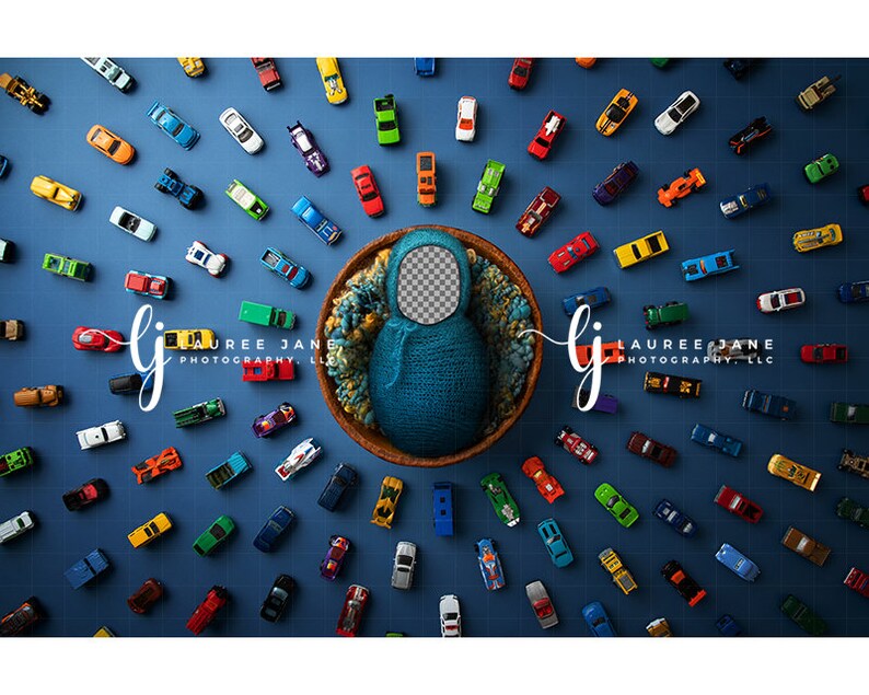May include: A newborn photography prop featuring a blue knitted cocoon nestled in a wooden bowl, surrounded by a multitude of colorful toy cars on a blue grid background. The image includes the text "LAUREE JANE PHOTOGRAPHY, LLC".