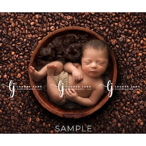 May include: A newborn baby sleeping in a wooden bowl filled with coffee beans. The baby is wearing a white and brown outfit. The bowl is surrounded by coffee beans.