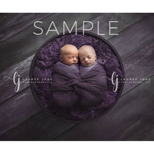 May include: Two newborn babies sleeping in a purple bowl, wrapped in purple swaddles. The bowl is on a dark purple wooden background. The image is labeled "SAMPLE" at the top.