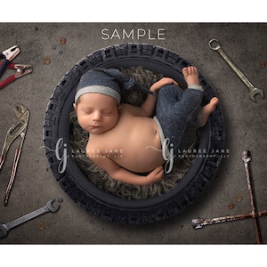 Puede incluir: Un bebé recién nacido con gorro y pantalón azul dentro de un neumático. Varias herramientas, incluyendo llaves y alicates, rodean al bebé sobre un fondo gris. La palabra "SAMPLE" está en la parte superior.
