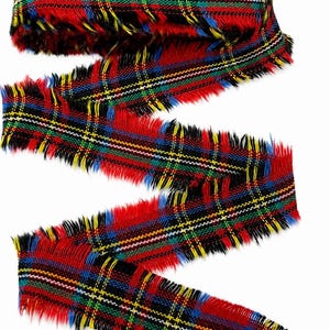 May include: A length of fabric ribbon featuring a vibrant plaid pattern in red, black, blue, green, and yellow. The ribbon has a distinct frayed, raw edge along both sides, creating a textured, fibrous appearance throughout the entire length.
