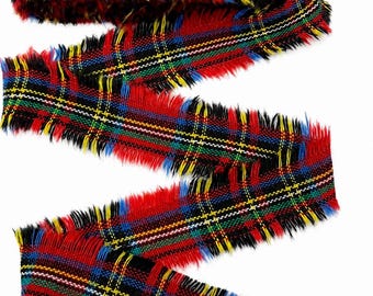 May include: A length of fabric ribbon featuring a vibrant plaid pattern in red, black, blue, green, and yellow. The ribbon has a distinct frayed, raw edge along both sides, creating a textured, fibrous appearance throughout the entire length.