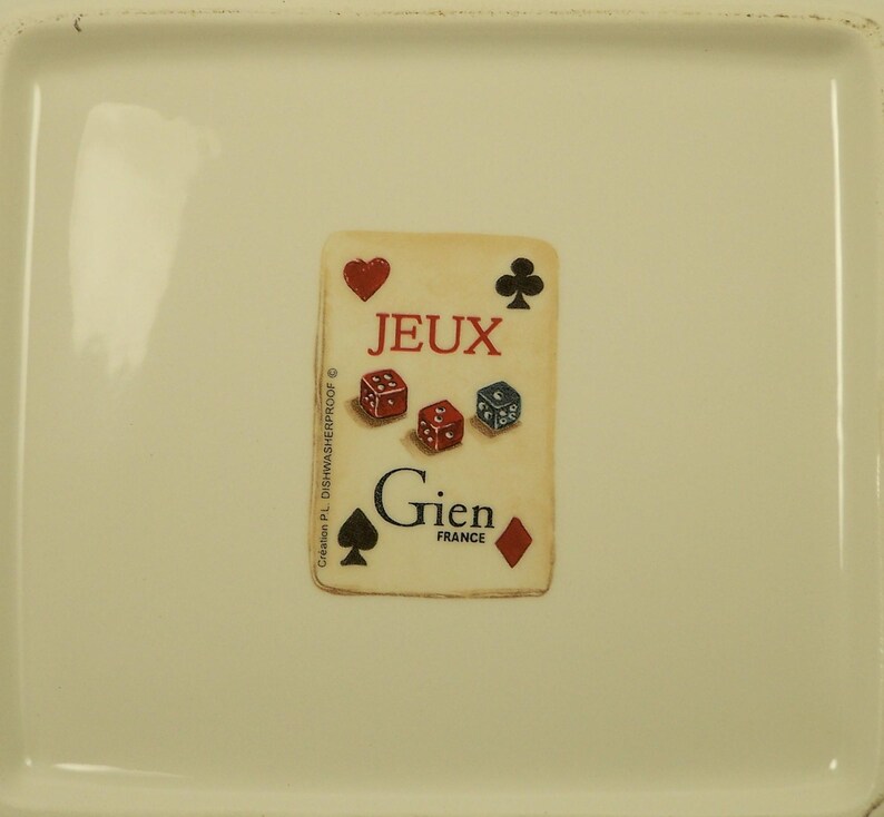 K&ouml;nnte beinhalten: Cremefarbene rechteckige Keramikschale mit Spielkartenmotiv. Die Karte zeigt das Wort "JEUX", W&uuml;rfel und Kartenfarben. Auf der Unterseite der Karte steht "Gien FRANCE".