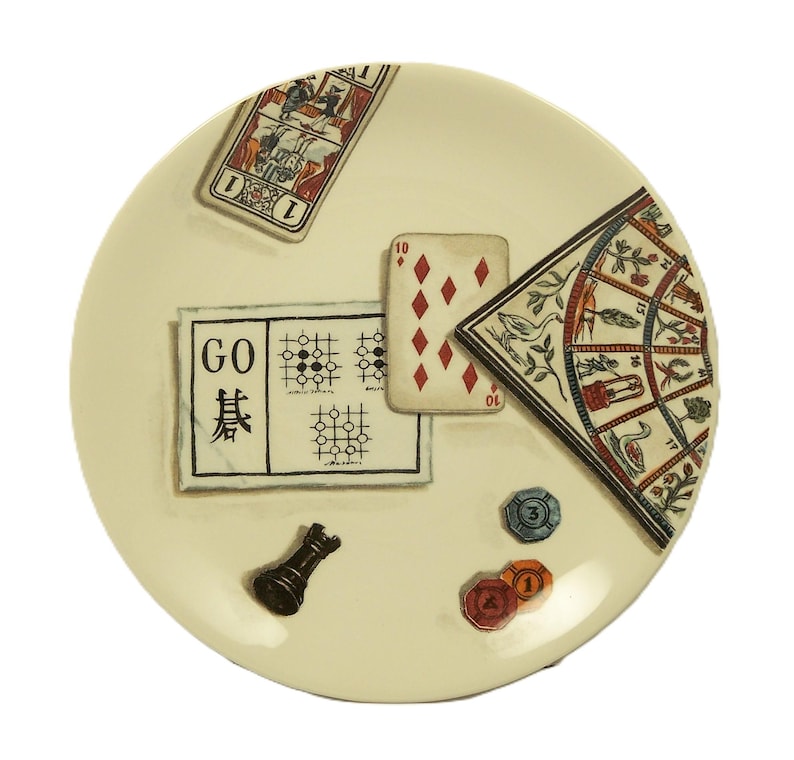 K&ouml;nnte beinhalten: Ein cremefarbener dekorativer Teller mit Illustrationen zum Thema Spiele. Er enth&auml;lt eine Spielkarte, ein Go-Brett, eine Spielkarte mit der Zahl 10, einen dekorativen F&auml;cher, eine Schachfigur und Pokerchips. Der Teller hat eine gl&auml;nzende Oberfl&auml;che.