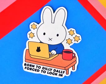 May include: A sticker featuring a white rabbit character wearing a blue shirt, working on a yellow laptop with a black bunny icon. The sticker includes a red mug and the text "BORN TO DILLY DALLY FORCED TO LOCK IN."