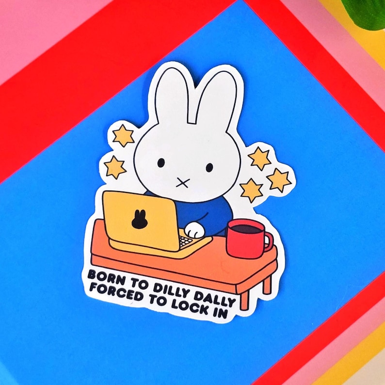 May include: A sticker featuring a white rabbit character wearing a blue shirt, working on a yellow laptop with a black bunny icon. The sticker includes a red mug and the text "BORN TO DILLY DALLY FORCED TO LOCK IN."