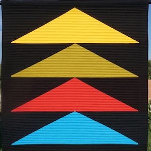 May include: A black background with four triangles layered on top of each other. The top triangle is yellow, the second is gold, the third is red, and the bottom is blue.