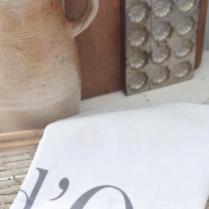 May include: White kitchen towel with the text "Old" printed in gray on it.