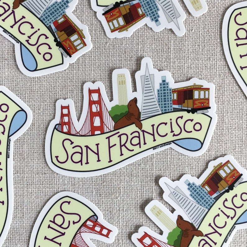 Several illustrated San Francisco vinyl stickers, scattered on a neutral background.