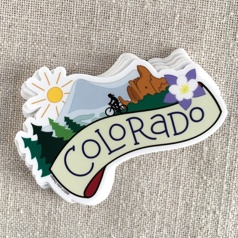 A stack of illustrated Colorado vinyl stickers on a neutral background.