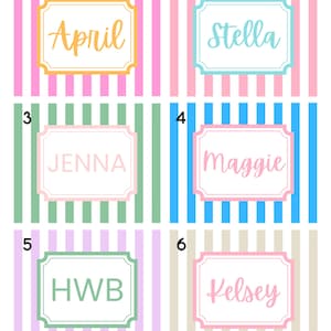 Puede incluir: Seis etiquetas con nombres y iniciales diferentes, cada una en un color &uacute;nico. Las etiquetas son rectangulares con un borde decorativo y est&aacute;n sobre un fondo a rayas de varios colores, incluyendo rosa, azul y verde.