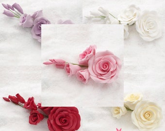 May include: Assortment of fondant flowers in various colors, including white, pink, red, and purple. The flowers are arranged on a white surface and are perfect for decorating cakes and cupcakes.