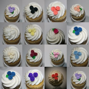 Puede incluir: Una colección de 12 cupcakes con glaseado de diferentes colores y decoraciones de flores de azúcar. Los cupcakes están dispuestos en una cuadrícula sobre un fondo blanco.