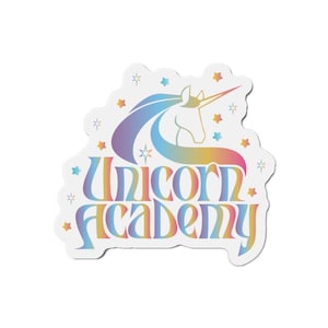 Puede incluir: Una pegatina blanca con un diseño de unicornio colorido y las palabras "Unicorn Academy". El unicornio tiene una melena y cola fluidas en tonos de azul, morado y amarillo. Estrellas de varios colores rodean el texto.