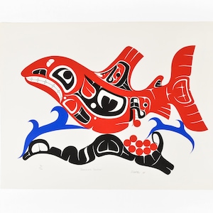 Könnte beinhalten: Eine stilisierte Illustration eines Lachses, der im Wasser schwimmt, dargestellt im traditionellen Stil der nordwestlichen Küsten-Indianer. Der Lachs ist rot, schwarz und blau. Das Bild ist mit "Salmon Salmon" betitelt und mit "Chuck 87" signiert.