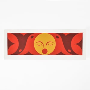 Puede incluir: Una impresión enmarcada de un diseño abstracto estilizado con dos pájaros rojos y marrones que flanquean un círculo amarillo con una cara estilizada. La cara tiene los ojos cerrados y una boca roja.