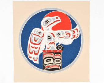 May include: A white eagle with red, blue, and gray markings is perched on a black and red totem pole. The eagle is surrounded by a blue circle with a red sun in the background.