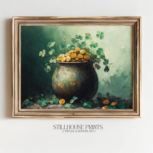 May include: A framed print featuring a pot of gold overflowing with coins, surrounded by shamrocks. The pot is dark green with a textured appearance, set against a green and white background. The print is labeled "STILLHOUSE PRINTS VINTAGE & MODERN ART".
