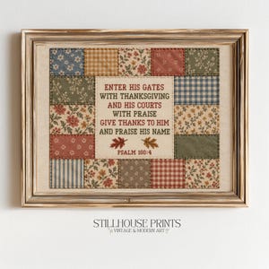 May include: A framed wall art piece featuring a central cream-colored panel with the text "ENTER HIS GATES WITH THANKSGIVING AND HIS COURTS WITH PRAISE GIVE THANKS TO HIM AND PRAISE HIS NAME PSALM 100:4" surrounded by a patchwork border of floral fabrics.