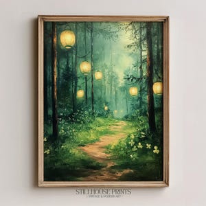 Puede incluir: Pintura enmarcada de una escena de bosque con un camino que atraviesa los árboles. Faroles cuelgan de los árboles, iluminando el camino. La pintura tiene una estética vintage, con el texto "STILLHOUSE PRINTS VINTAGE & MODERN ART" en la parte inferior.