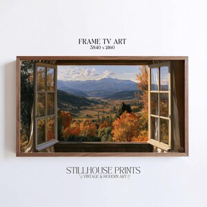 Puede incluir: Una impresión de arte digital para Frame TV que muestra una vista desde una ventana abierta hacia un valle montañoso en otoño. El paisaje presenta árboles naranjas y amarillos, montañas azules distantes y un cielo despejado. Texto: FRAME TV ART 3840 x 2160 STILLHOUSE PRINTS.