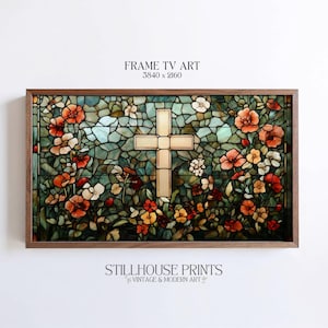 Puede incluir: Una obra de arte en vitral enmarcada con una cruz crema en el centro, rodeada de flores rojas, naranjas y amarillas. El fondo es un mosaico de tonos verdes y azules. El marco de madera oscura encierra la obra de arte. El texto "FRAME TV ART" y "STILLHOUSE PRINTS" son visibles.