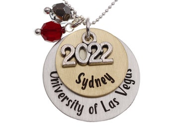 May include: Silver necklace with a gold charm that says "Sydney" and "University of Las Vegas" with the year "2022" on a smaller charm. The necklace has red and silver beads.