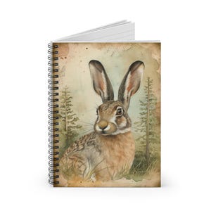 May include: A watercolor painting of a brown and white rabbit with large ears, sitting in a forest setting. The rabbit is looking directly at the viewer. The background is a soft green and brown, with trees and foliage.