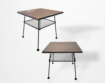 May include: Two black metal end tables with wood tops and wire shelves. The tables are on a white background.