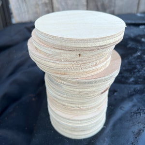 May include: A stack of round, unfinished wooden circles, likely for crafts or DIY projects.