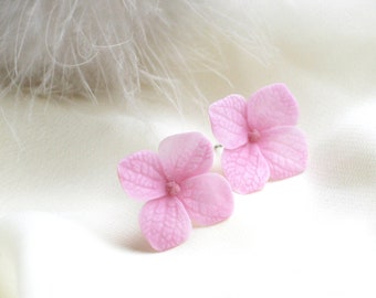 May include: A pair of pink hydrangea flower earrings. The earrings are made of polymer clay and have a realistic look.