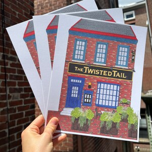 May include: Three white cards with a hand-drawn illustration of a red brick building with a blue door and windows. The building has a sign that reads "The Twisted Tail".