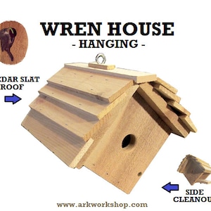 May include: A wooden wren house with a cedar slat roof, a side cleanout door, and a hanging loop. The house is designed for birds to nest in. "WREN HOUSE - HANGING -" and "www.arkworkshop.com" are printed on the image.