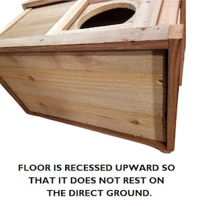 May include: A wooden birdhouse with a raised floor to prevent contact with the ground. The floor is made of wood planks and the house has a small opening for birds to enter.