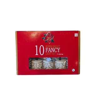 May include: A red rectangular box containing a set of 10 super bright fancy lights. The packaging features a poinsettia graphic, the text 10 SUPER BRIGHT FANCY LIGHT SET, and indicates a length of 9 3/4 feet long with visible pinecone-shaped covers.