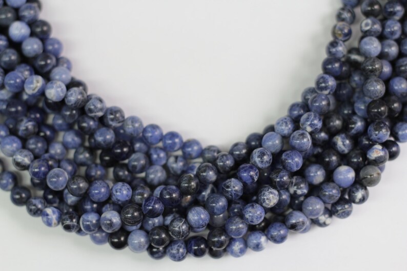 May include: A strand of blue and white gemstone beads. The beads are round and have a smooth, polished finish.