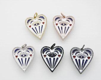 Puede incluir: Cinco colgantes en forma de corazón con un diseño de ojo turco. Los colgantes están hechos de metal y tienen un fondo de esmalte blanco con acentos azules y rojos. Los colgantes están disponibles en oro, oro rosa, plata y negro.